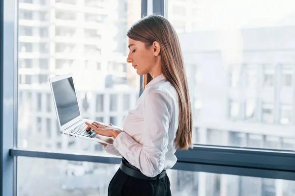 Standing Laptop Young Woman White Formal Clothes Indoors Modern Office — Stockfoto