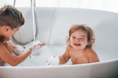 İki çocuk evde banyo yapıp eğleniyorlardı. Kamera pozu..