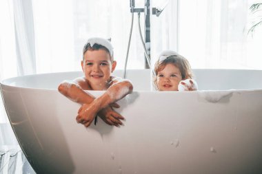 İki çocuk evde banyo yapıp eğleniyorlardı. Kamera pozu..