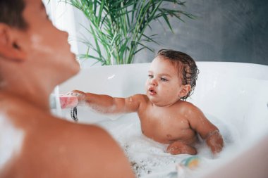 İki çocuk evde banyo yapıp eğleniyor..