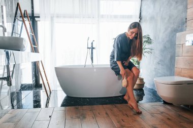 Beautiful young woman have free time at home in the bath.