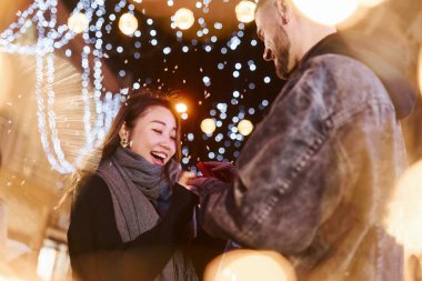 Adam evlenme teklif ediyor. Mutlu, çok ırklı bir çift şehrin dışında yeni yılı kutluyor..