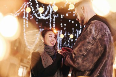 Adam evlenme teklif ediyor. Mutlu, çok ırklı bir çift şehrin dışında yeni yılı kutluyor..