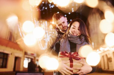 Hediye kutusu var. Mutlu, çok ırklı bir çift şehrin dışında yeni yılı kutluyor..