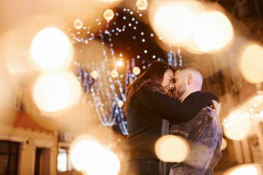 Happy multiracial couple together outdoors in the city celebrating New year.