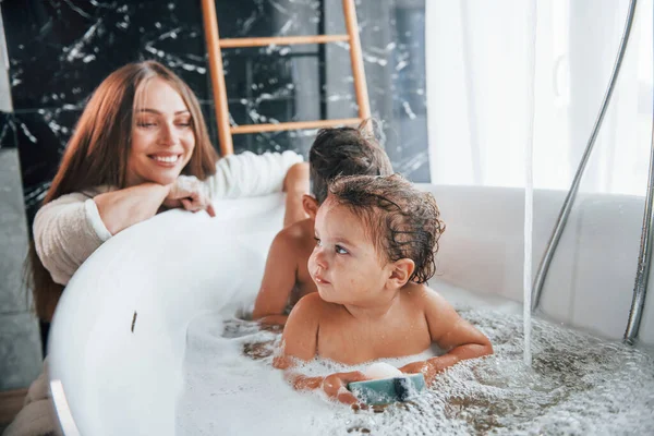 Young Mother Helps Her Son Daughter Two Kids Washing Bath — Stock fotografie