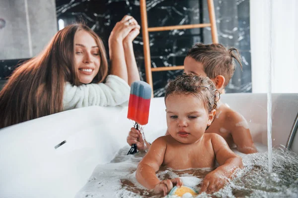 Young Mother Helps Her Son Daughter Two Kids Washing Bath — Stockfoto