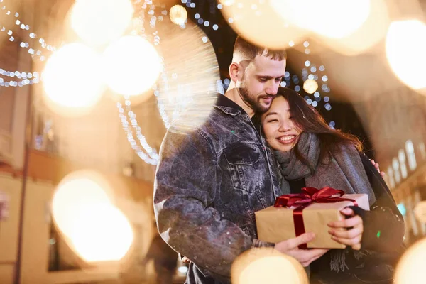 Hediye kutusu var. Mutlu, çok ırklı bir çift şehrin dışında yeni yılı kutluyor..