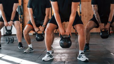 Ağırlık kaldırma. Bir grup genç sporcu spor salonunda iç içe geçiyor..