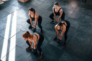 Ağırlık kaldırma. Bir grup genç sporcu spor salonunda iç içe geçiyor..