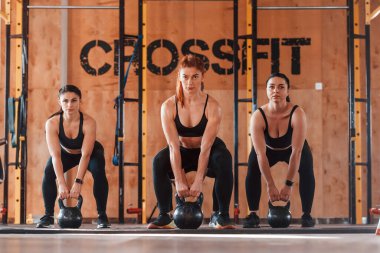 Halter kullanarak. Bir grup genç sporcu spor salonunda iç içe geçiyor..