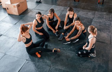 Plank egzersizi. Bir grup genç sporcu spor salonunda iç içe geçiyor..