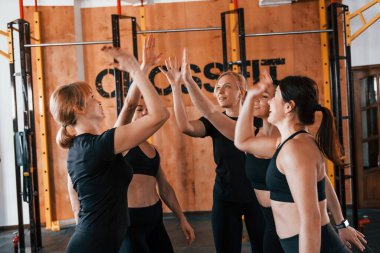 Mola verdim. Bir grup genç sporcu spor salonunda iç içe geçiyor..