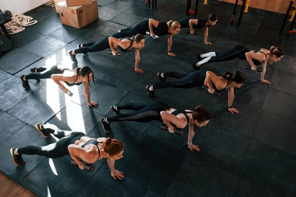 Halter kullanarak. Bir grup genç sporcu spor salonunda iç içe geçiyor..