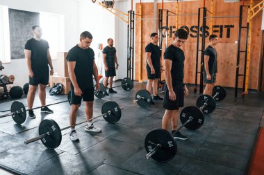 Bir grup genç sporcu spor salonunda iç içe geçiyor..