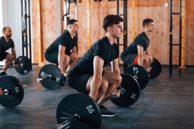 Egzersiz yapmakla meşgul. Bir grup genç sporcu spor salonunda iç içe geçiyor..