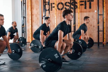 Egzersiz yapmakla meşgul. Bir grup genç sporcu spor salonunda iç içe geçiyor..