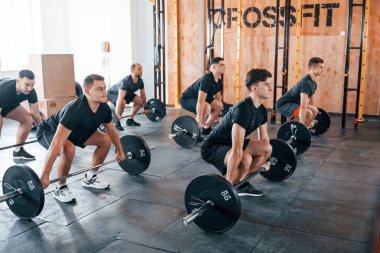Egzersiz yapmakla meşgul. Bir grup genç sporcu spor salonunda iç içe geçiyor..