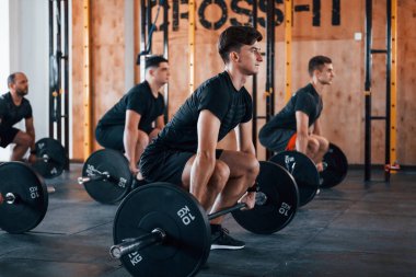 Egzersiz yapmakla meşgul. Bir grup genç sporcu spor salonunda iç içe geçiyor..