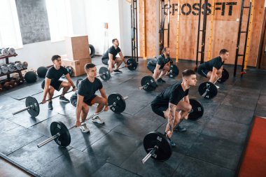 Egzersiz yapmakla meşgul. Bir grup genç sporcu spor salonunda iç içe geçiyor..
