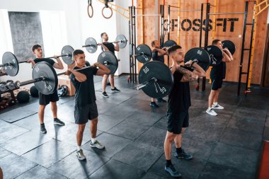 Bir grup genç sporcu spor salonunda iç içe geçiyor..