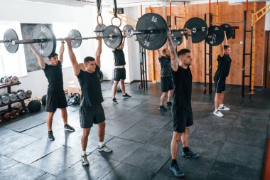 Bir grup genç sporcu spor salonunda iç içe geçiyor..