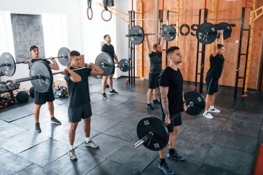 Bir grup genç sporcu spor salonunda iç içe geçiyor..