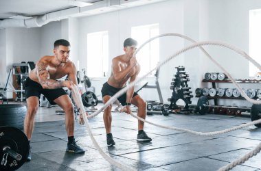 Spor vücutlu genç insanlar düğüm atarak çapraz uyum sağlıyorlar..