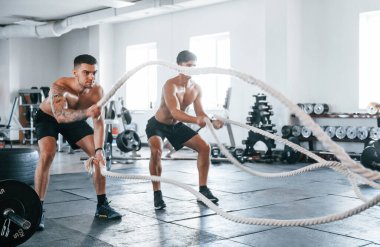 Spor vücutlu genç insanlar düğüm atarak çapraz uyum sağlıyorlar..