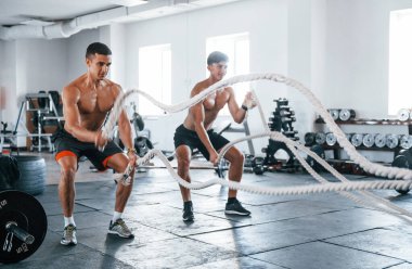 Spor vücutlu genç insanlar düğüm atarak çapraz uyum sağlıyorlar..