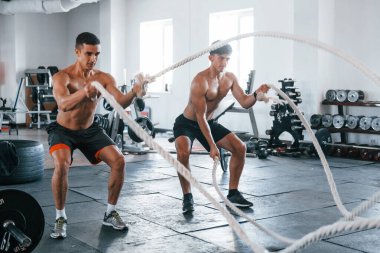 Spor vücutlu genç insanlar düğüm atarak çapraz uyum sağlıyorlar..