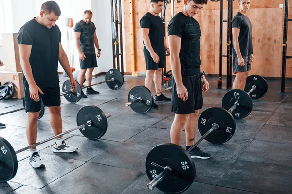 Bir grup genç sporcu spor salonunda iç içe geçiyor..