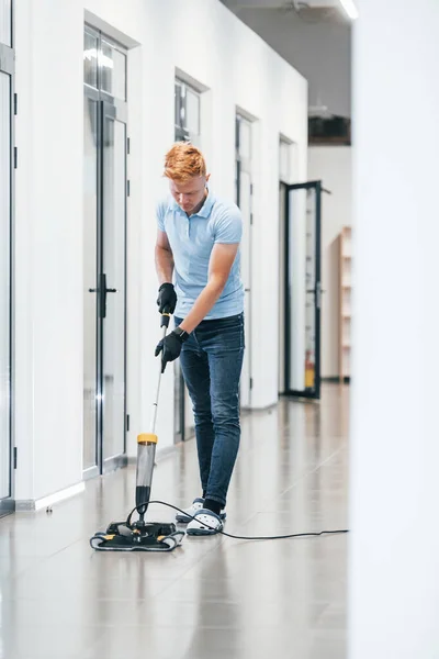 Young Man Works Modern Office Uses Vacuum Cleaner — Zdjęcie stockowe