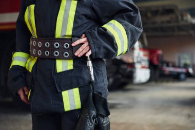 Close up view. Female firefighter in protective uniform standing near truck.