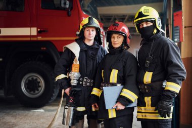 Kamera için poz vermek. İstasyondaki bir grup koruyucu üniformalı itfaiyeci....