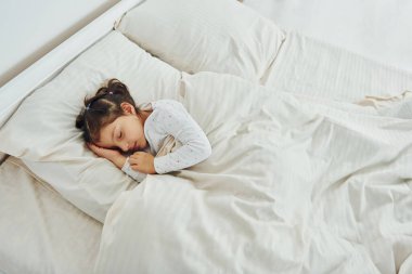 Küçük kız uyuyor. Gündüz vakti güzel, modern yatak odasının iç tasarımı ve tasarımı..