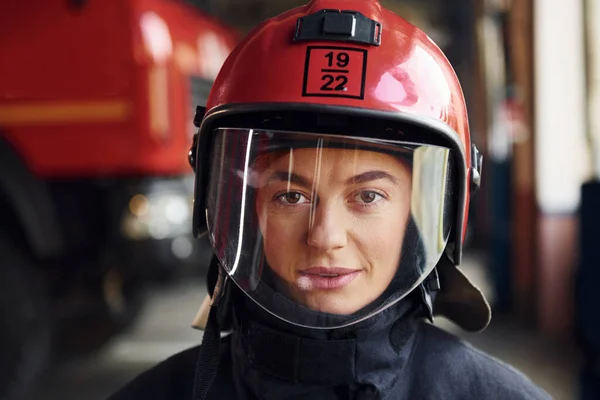 Stock image Close up view. Female firefighter in protective uniform standing near truck.