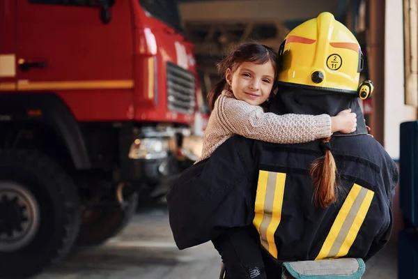 快乐的小女孩和身着防护服的女消防员在一起 — 图库照片