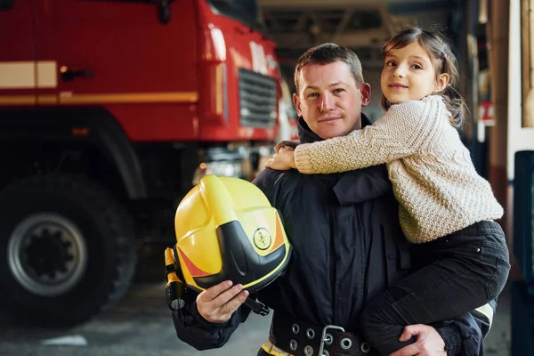 快乐的小女孩和身穿防护服的男性消防员在一起 — 图库照片