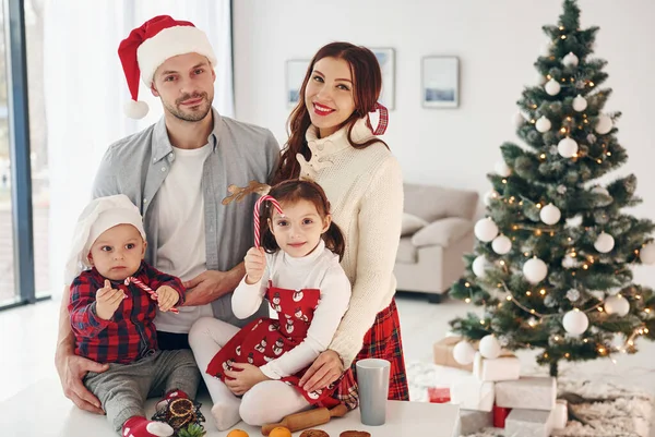 对着冷杉坐着美丽的家庭在家里庆祝新年和圣诞节 — 图库照片