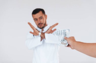 Sıhhiye rüşvet almaz. Beyaz arka planda duran yakışıklı genç adam..