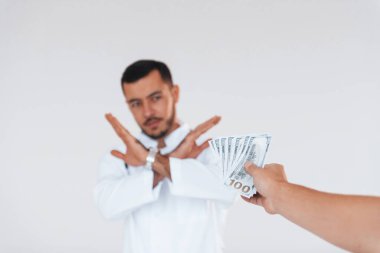 Sıhhiye rüşvet almaz. Beyaz arka planda duran yakışıklı genç adam..