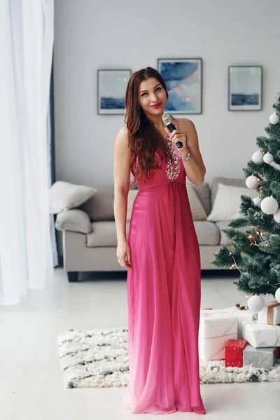 ピンクのドレス歌で美しい女性屋内で新年パーティー — ストック写真