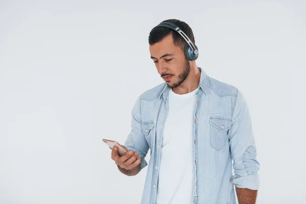 Listens Music Headphones Young Handsome Man Standing Indoors White Background — Fotografia de Stock