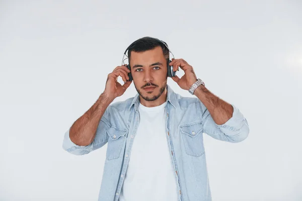Listens Music Headphones Young Handsome Man Standing Indoors White Background — Stockfoto