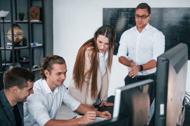 Grafikleri takip ediyor. Borsacılardan oluşan bir ekip modern ofiste birçok ekran ekranı ile çalışır..