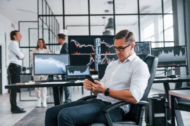 Sıradan bir ofis günü. Borsacılardan oluşan bir ekip kapalı alanda birçok ekran ile çalışır..