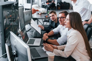 Bilgi analiz ediliyor. Borsacılardan oluşan bir ekip modern ofiste birçok ekran ekranı ile çalışır..