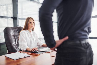 Dikiz aynası. Resmi giyinmiş bir kadın ve bir adam ofis içinde masa başında birlikte çalışıyorlar..