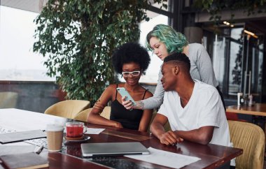 Alternatif saçlı, yeşil saçlı, çok ırklı bir grup insan kapalı alanda birlikte çalışıyorlar..